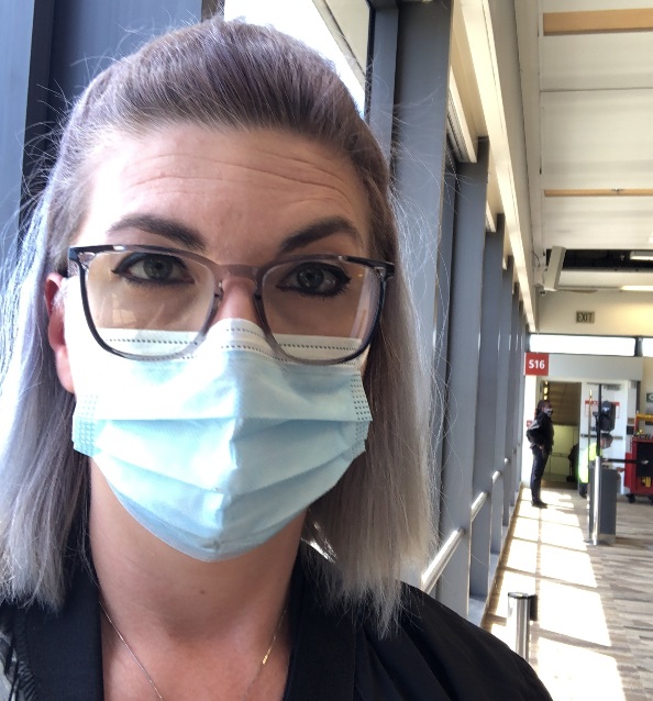 The author wearing protective eyewear and a medical mask, getting read to board an international flight
