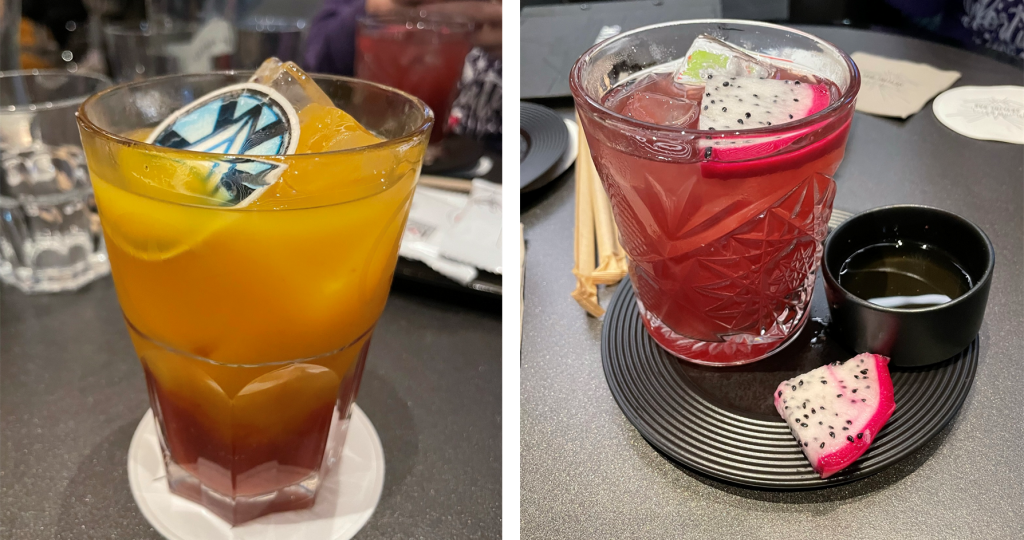 Drinks from the Skyline Dar. Left, Orange Fusion Reactor, a glass of orange liquid; right, Dark Magic, and glass of red liquid with dragon fruit garnish.